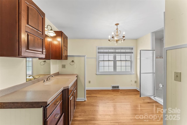 kitchen with sink, decorative light fixtures, plenty of natural light, and a notable chandelier