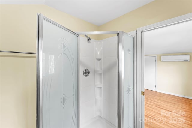 bathroom featuring walk in shower, hardwood / wood-style floors, and a wall unit AC