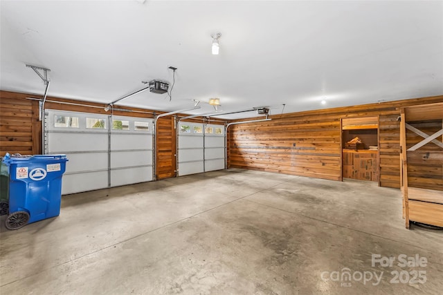 garage with wooden walls and a garage door opener