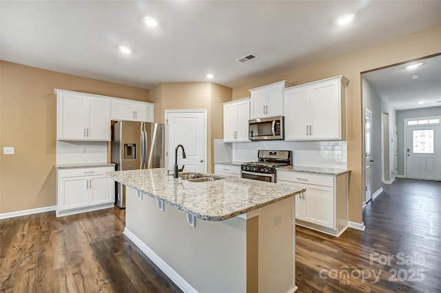 kitchen featuring white cabinets, sink, stainless steel appliances, and a center island with sink