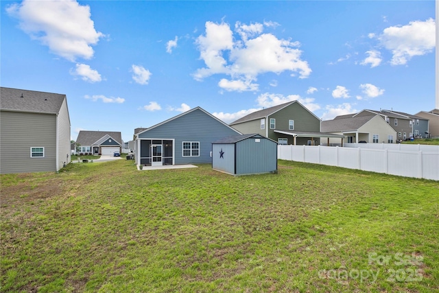 rear view of house with a storage shed, a yard, and a sunroom