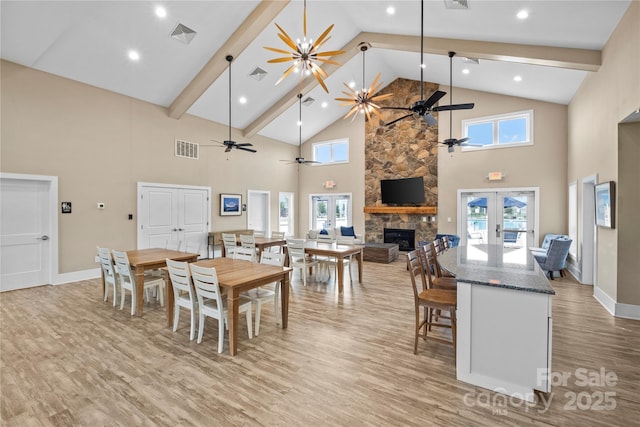 dining area with high vaulted ceiling, light hardwood / wood-style floors, and french doors