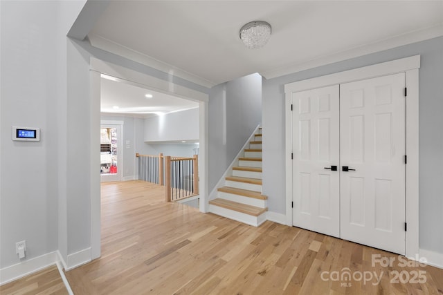 hall with crown molding and light hardwood / wood-style flooring