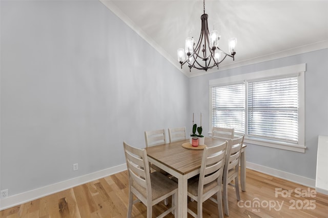 dining space with an inviting chandelier, crown molding, and light hardwood / wood-style flooring