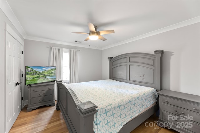 bedroom with ceiling fan, crown molding, and light hardwood / wood-style floors