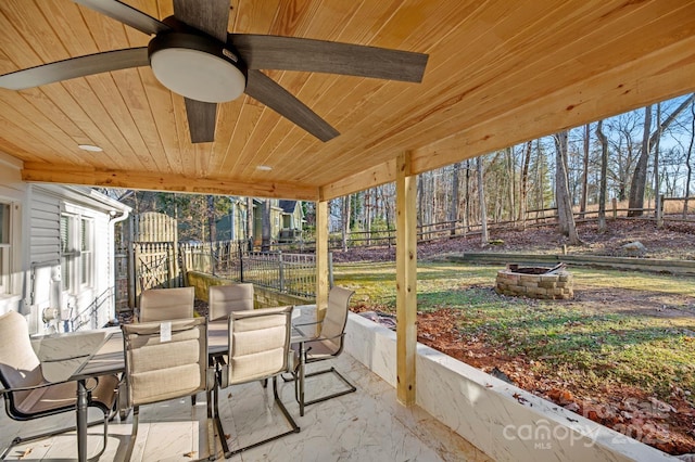 view of patio with ceiling fan and a fire pit