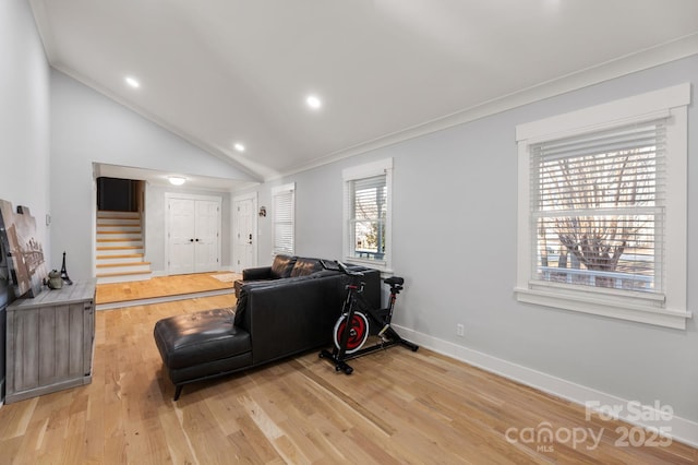 living room featuring lofted ceiling, ornamental molding, and light hardwood / wood-style floors