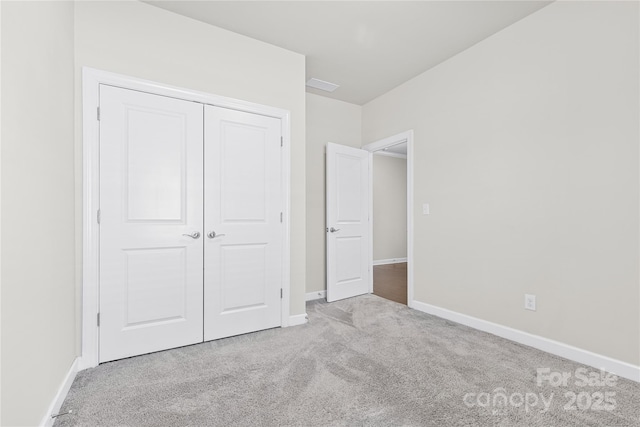 unfurnished bedroom with a closet and light colored carpet