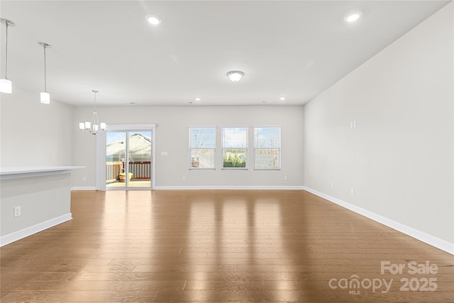 9307 Dufaux Dr, Charlotte, NC 28278 - unfurnished living room with baseboards, recessed lighting, a notable chandelier, and hardwood / wood-style flooring