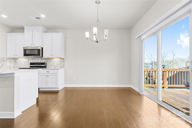 9307 Dufaux Dr, Charlotte, NC 28278 - kitchen with appliances with stainless steel finishes, tasteful backsplash, baseboards, an inviting chandelier, and hardwood / wood-style floors