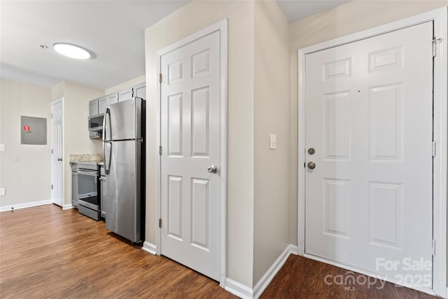 interior space with stainless steel appliances, dark hardwood / wood-style floors, and electric panel