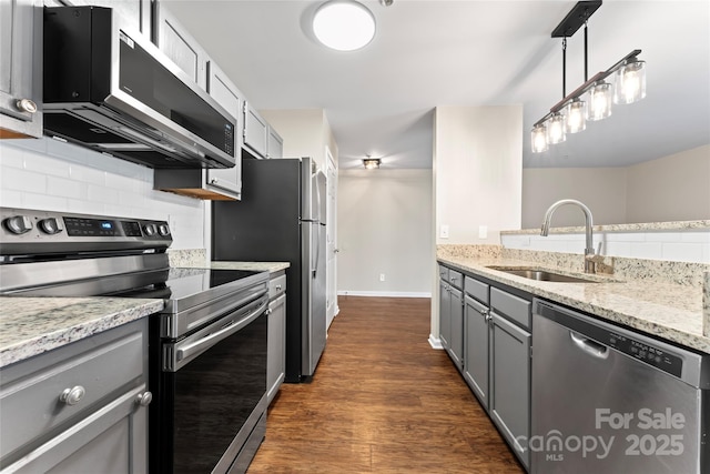 kitchen with sink, decorative light fixtures, appliances with stainless steel finishes, gray cabinets, and backsplash