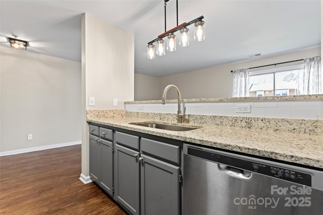 kitchen with pendant lighting, sink, gray cabinetry, stainless steel dishwasher, and dark wood-type flooring