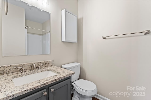 bathroom featuring vanity, walk in shower, and toilet