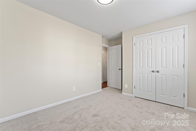 unfurnished bedroom with light carpet and a closet