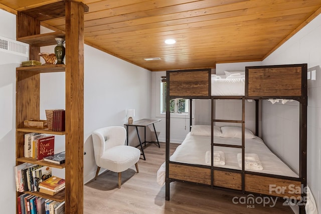 bedroom featuring vaulted ceiling, hardwood / wood-style flooring, crown molding, and wooden ceiling