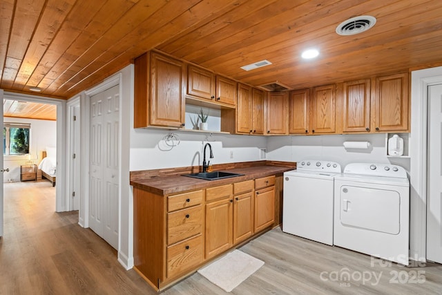 laundry room with cabinets, independent washer and dryer, wooden ceiling, and sink