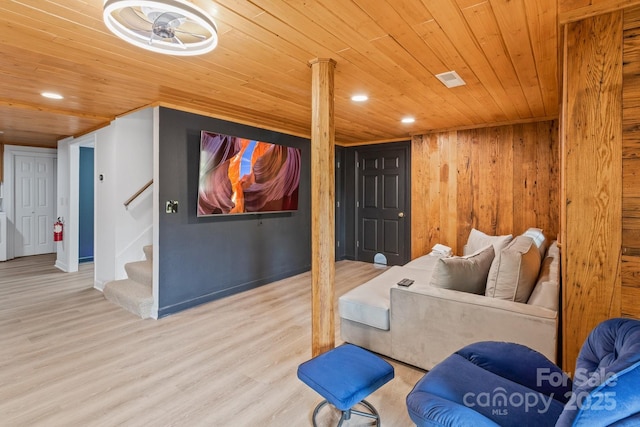 living room featuring wooden ceiling, wood walls, and light wood-type flooring