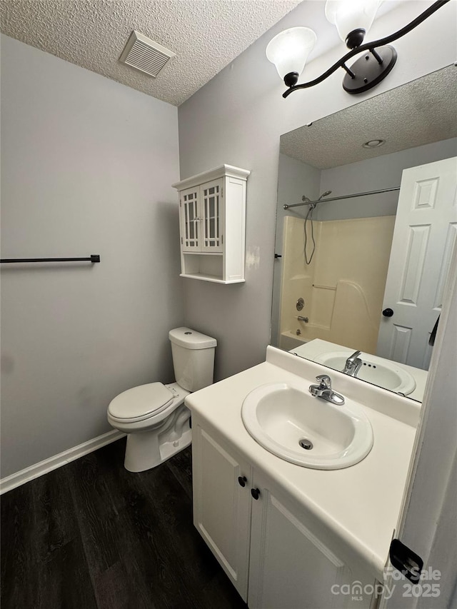 full bathroom with a textured ceiling, hardwood / wood-style floors, shower / tub combination, toilet, and vanity