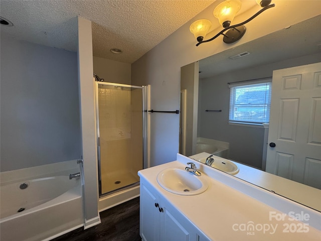 bathroom featuring vanity, a textured ceiling, hardwood / wood-style floors, and plus walk in shower