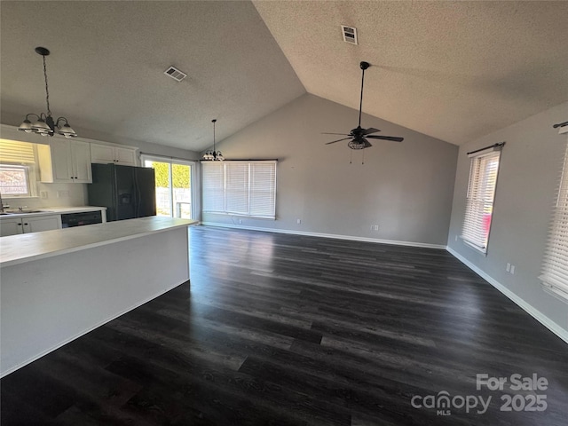 kitchen featuring white cabinetry, vaulted ceiling, pendant lighting, black appliances, and dark wood-type flooring