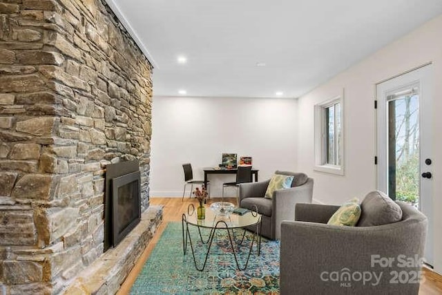 living room featuring a fireplace, plenty of natural light, and light hardwood / wood-style flooring