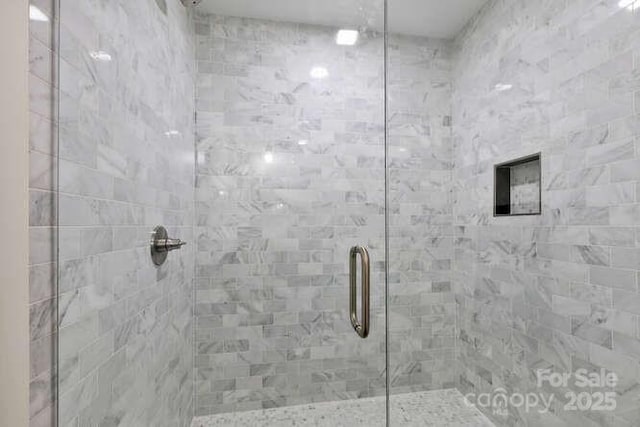 bathroom featuring a shower with door