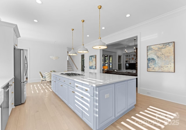 kitchen with hanging light fixtures, a center island, stainless steel appliances, light hardwood / wood-style floors, and white cabinetry