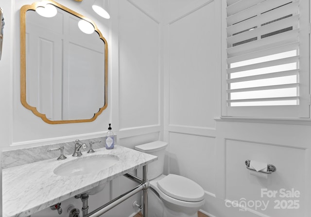 bathroom featuring toilet, radiator heating unit, and sink