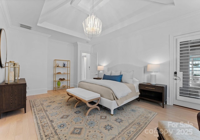 bedroom featuring a notable chandelier, access to exterior, light wood-type flooring, and a tray ceiling