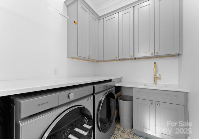 washroom featuring sink, washing machine and dryer, crown molding, and cabinets