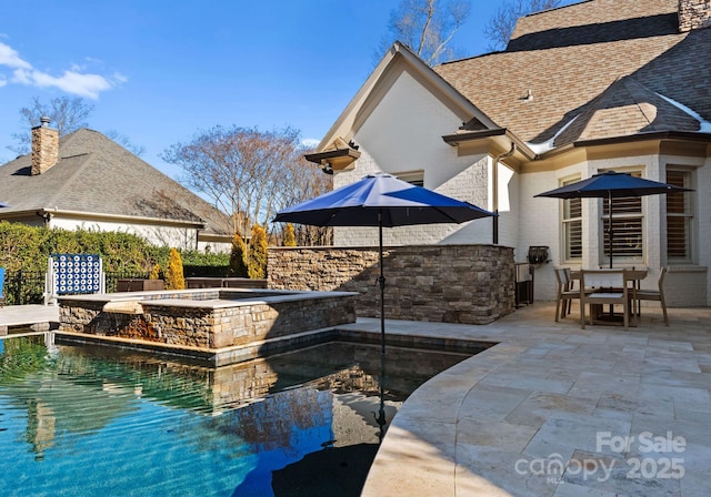 view of swimming pool featuring a patio and an in ground hot tub