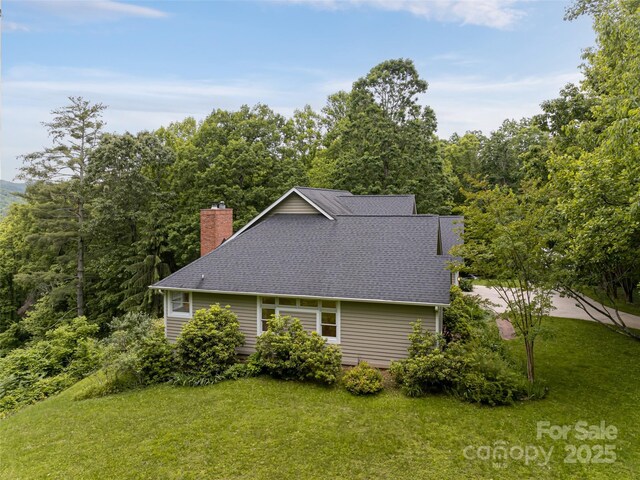15 Breckenridge Dr, Fairview, NC 28730 - view of side of property featuring a yard, a chimney, and a shingled roof