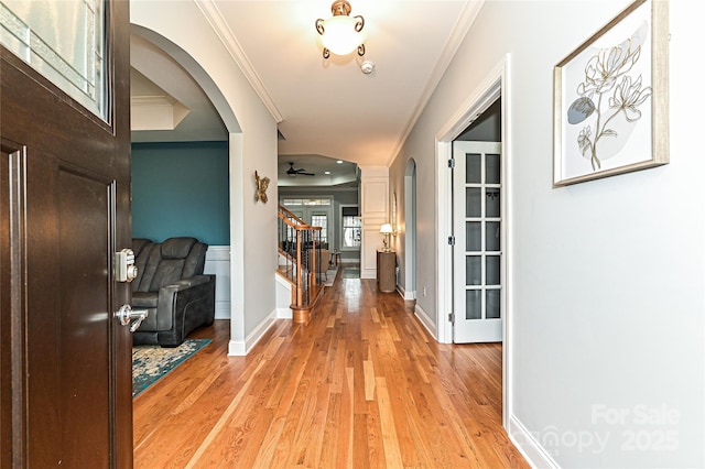 hall featuring ornamental molding and light hardwood / wood-style flooring