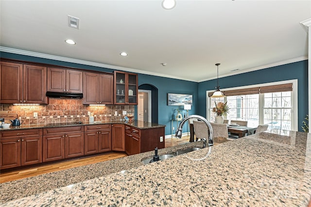 kitchen featuring decorative light fixtures, sink, decorative backsplash, light stone counters, and black electric cooktop