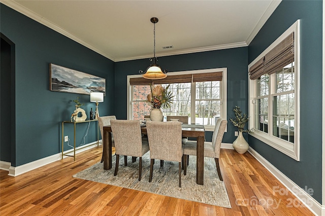 dining space with crown molding and hardwood / wood-style floors