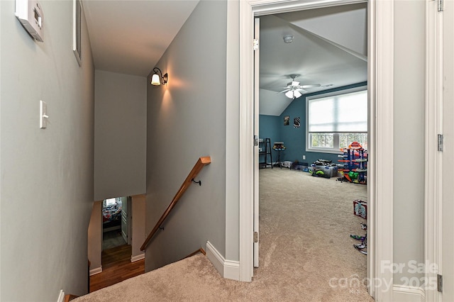 corridor featuring lofted ceiling and light carpet