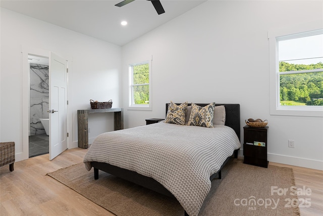 bedroom with ensuite bathroom, lofted ceiling, light wood-type flooring, and ceiling fan