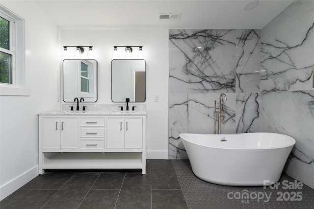 bathroom featuring tile patterned flooring, vanity, and a bathtub