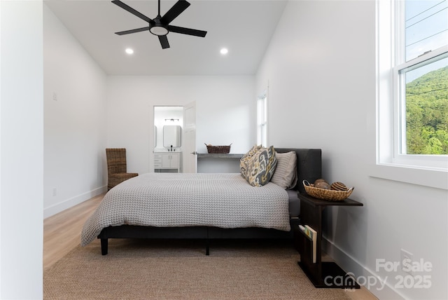 bedroom with ceiling fan, connected bathroom, and hardwood / wood-style floors