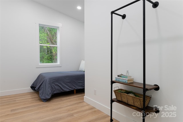 bedroom with light hardwood / wood-style flooring and vaulted ceiling