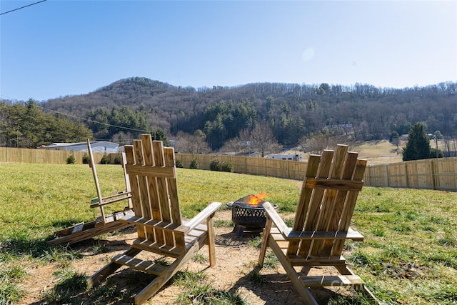 view of yard featuring a mountain view and an outdoor fire pit