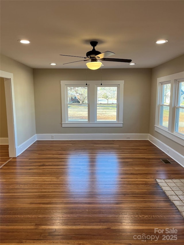 unfurnished room featuring dark wood-type flooring, ceiling fan, and plenty of natural light