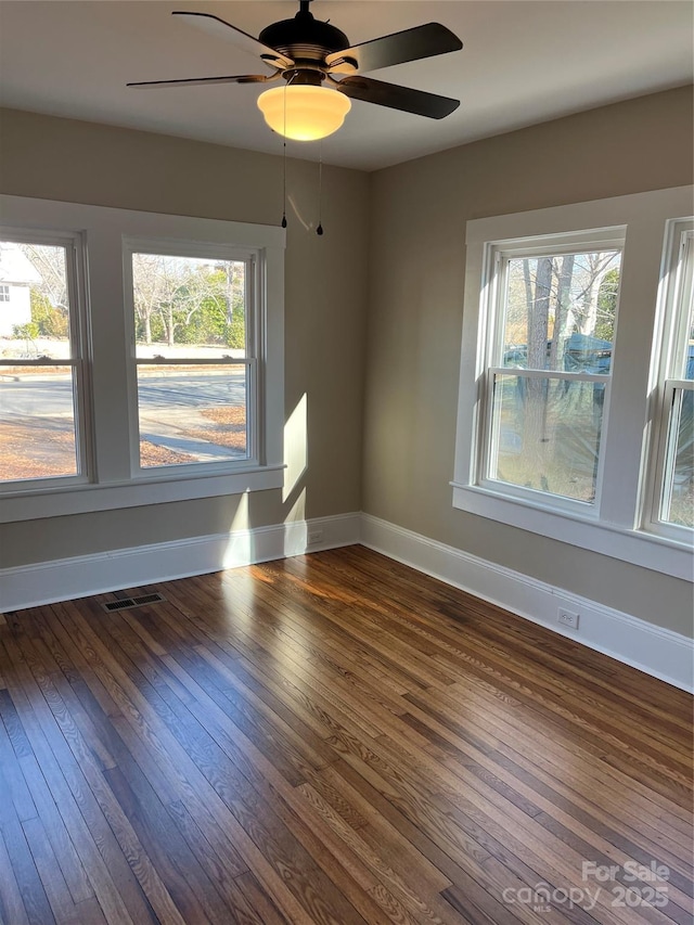 empty room featuring ceiling fan and dark wood-type flooring