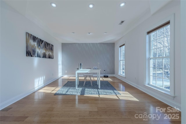 unfurnished dining area with ornamental molding and wood-type flooring