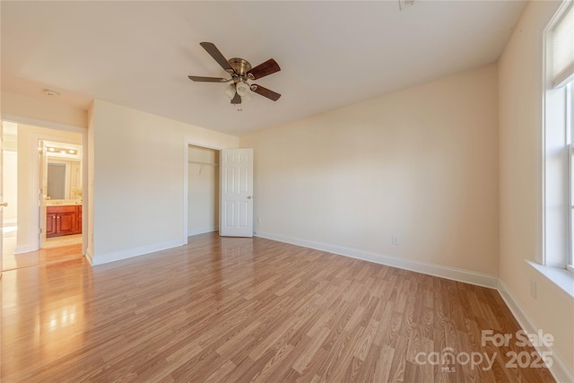 empty room with ceiling fan and light hardwood / wood-style flooring