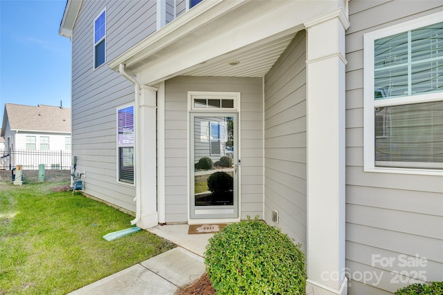 property entrance with a lawn