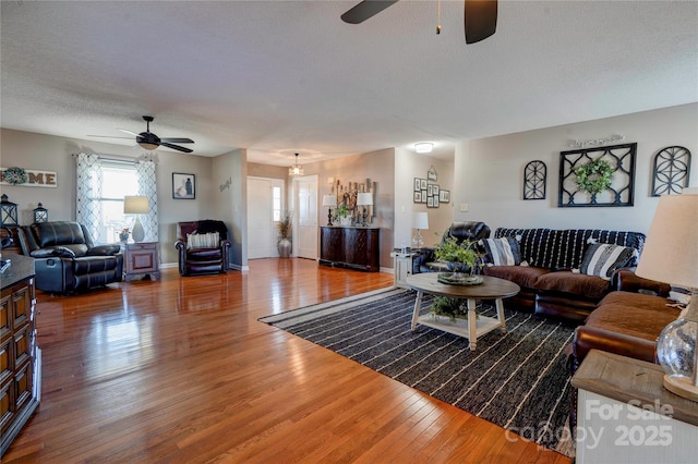 living room with ceiling fan, hardwood / wood-style floors, and a textured ceiling