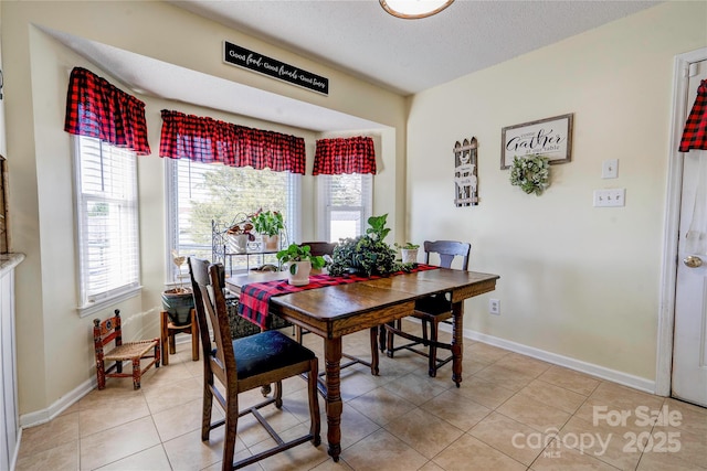 tiled dining area with a textured ceiling