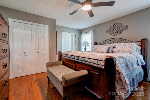 bedroom featuring hardwood / wood-style flooring, ceiling fan, and a textured ceiling